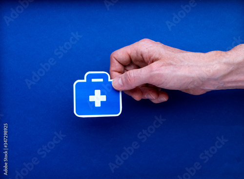 Illustration dessin malette médecin tenu par une main d'homme isolé sur fond bleu