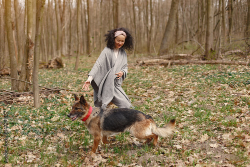 Woman in a forest. Adult lady walks. Lady playing with a dog.