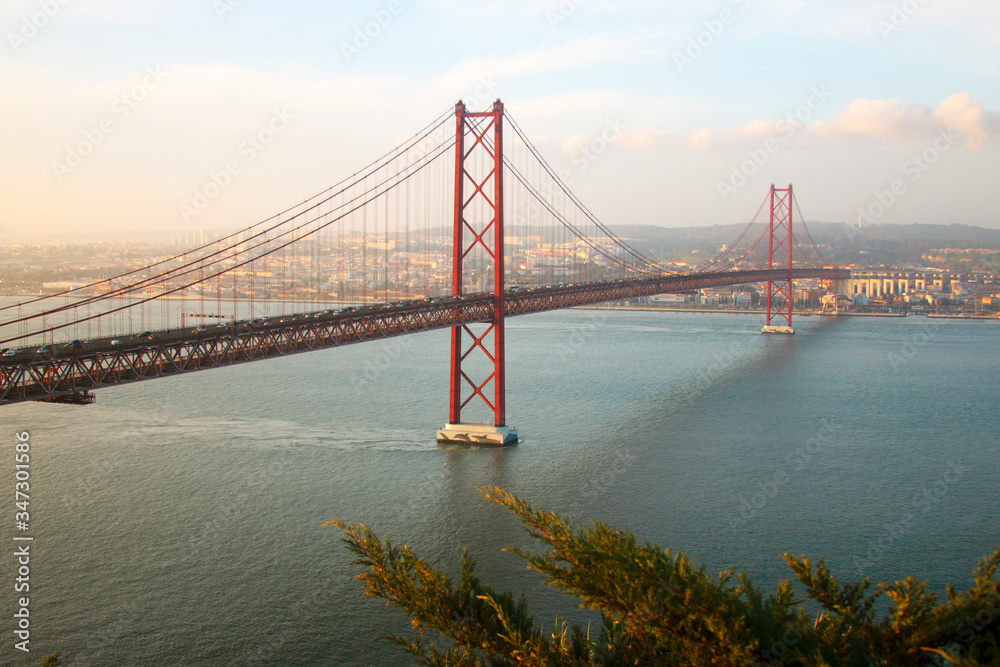 View of 25th of April Bridge, a suspension bridge connecting the city of Lisbon, capital of Portugal, to the municipality of Almada on the left (south) bank of the Tagus river. Lisbon, Portugal View of 25th of April Bridge, a suspension bridge connecting the city of Lisbon, capital of Portugal, to the municipality of Almada on the left (south) bank of the Tagus river. Lisbon, Portugal