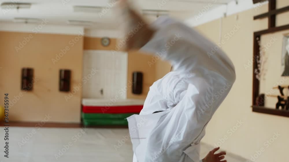 Karate man fighter exercising punching and kicking techniques during training at the dojo.Martial Art Concept