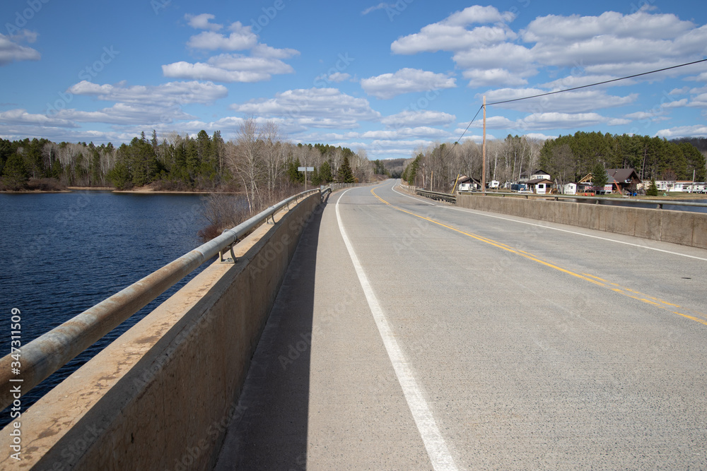 A northern Ontario highway pass over a lake on a bright spring day