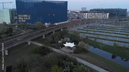 Aerial footage about the metro running in Copenhagen during the sunset, recorded from a drone point of view.