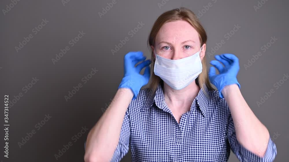 Young Caucasian woman in blue gloves wearing a mask to protect from coronavirus Young Caucasian woman in blue gloves wearing a mask to protect from coronavirus