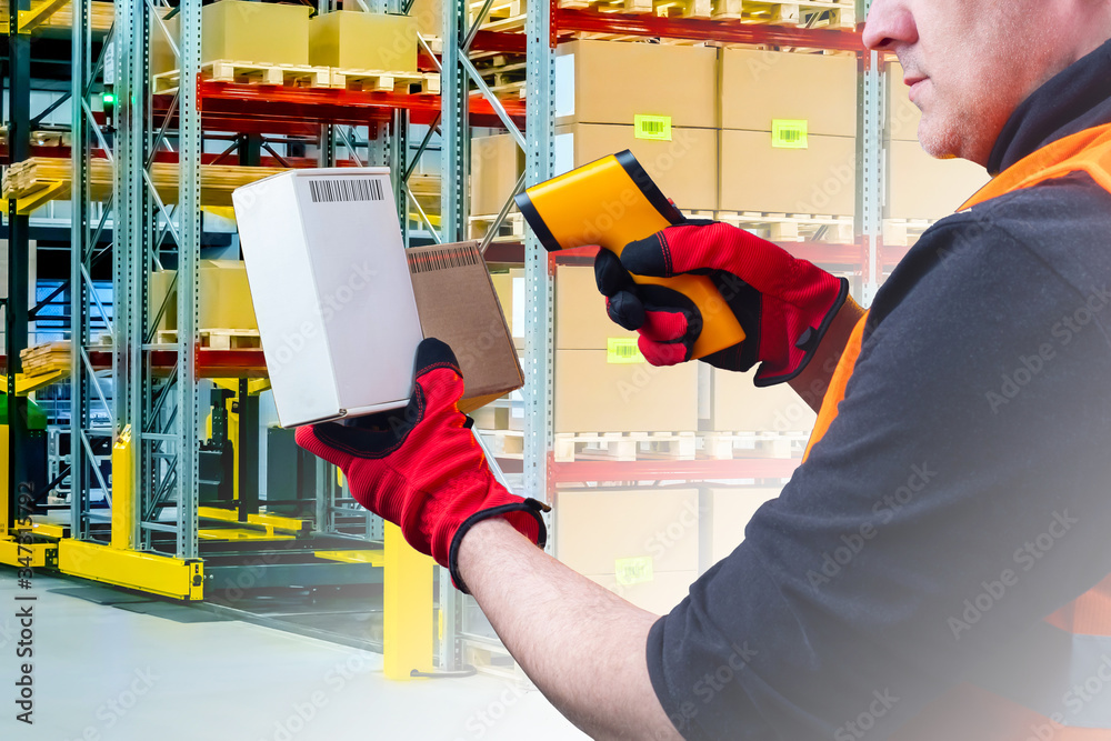 Man works in a warehouse. Human scans barcodes on boxes. Concept