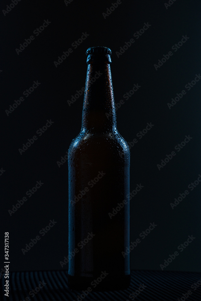 beer bottle with drops drink without label on a dark background beer bottle with drops drink without label on a dark background