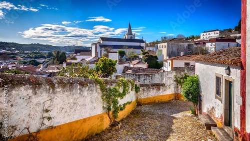 A scenic medieval townscape at the cobblestone footpaths of Obidos, Portugal photo