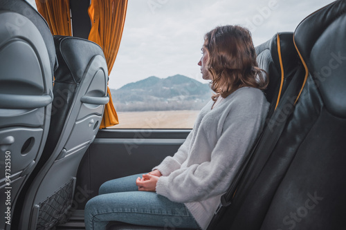 Young woman sitting on a bus looking out the window