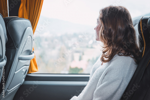 Young woman sitting on a bus looking out the window
