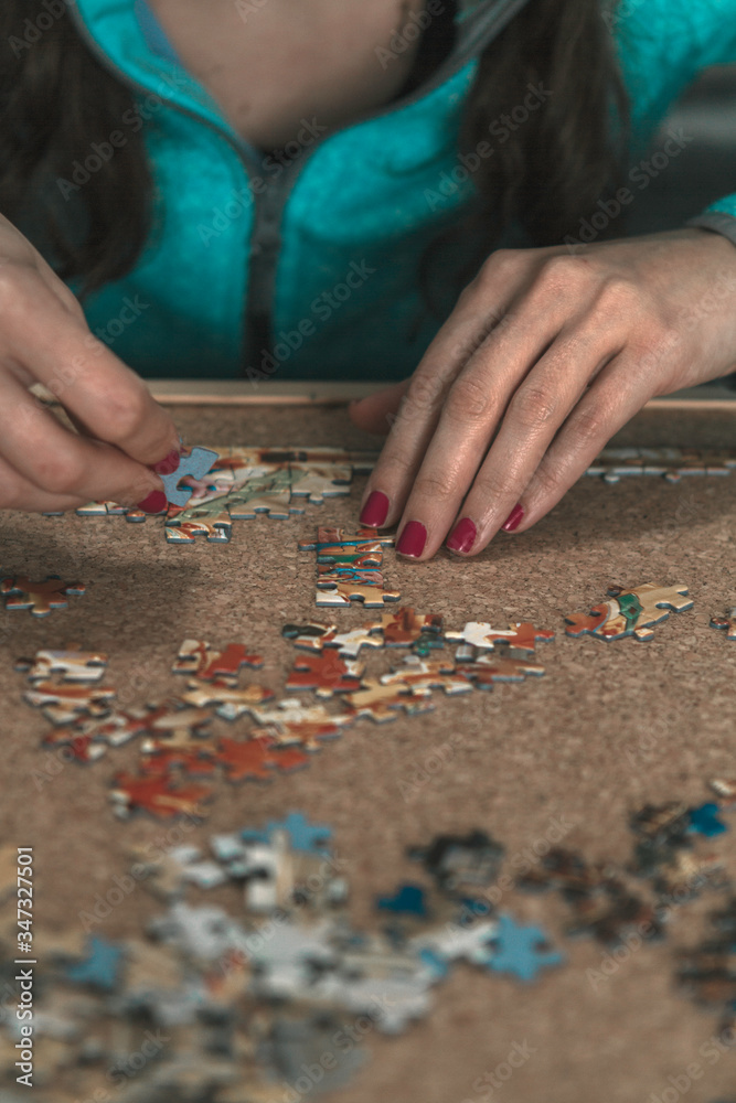 woman making a puzzle on brown cork. Solutions and spatial vision woman making a puzzle on brown cork. Solutions and spatial vision