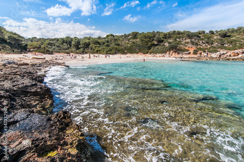 Landscape of sky, sea and people on the beach. Cala Sa Nau, Majorca