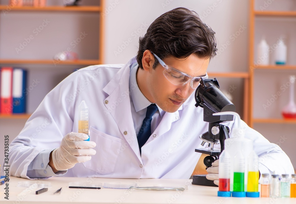 Young handsome biochemist working in the lab Young handsome biochemist working in the lab
