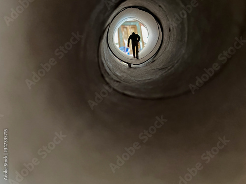 a miniature world, man goes home through a cardboard tunnel
