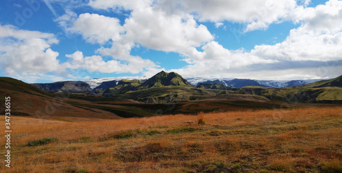 Field, hills, mountain and glacier landscape with blue sky and clouds - Laugavegur trail, Iceland
