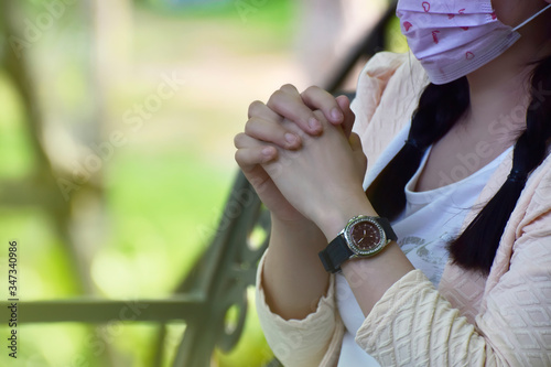 A woman sitting on a chair
In the garden on her wrists are expensive luxury watches.