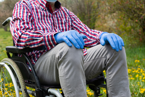 Disabled enderly man's hands with gloves photo