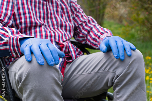 Disabled enderly man's hands with gloves