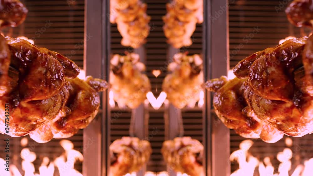 Symmetrically aligned chickens on spikes rotating in rotisserie between walls of flames