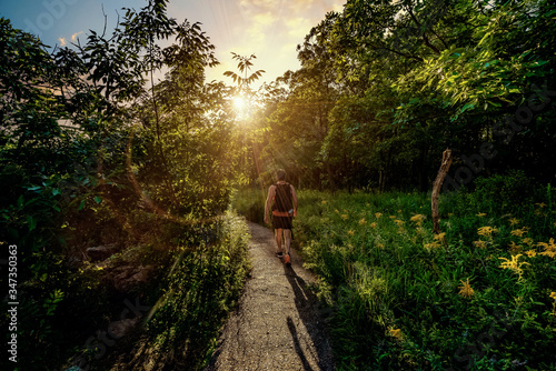 A hiker treks on a footpath in Devil's Lake State Park during sunset in Baraboo, Wisconsin USA. photo