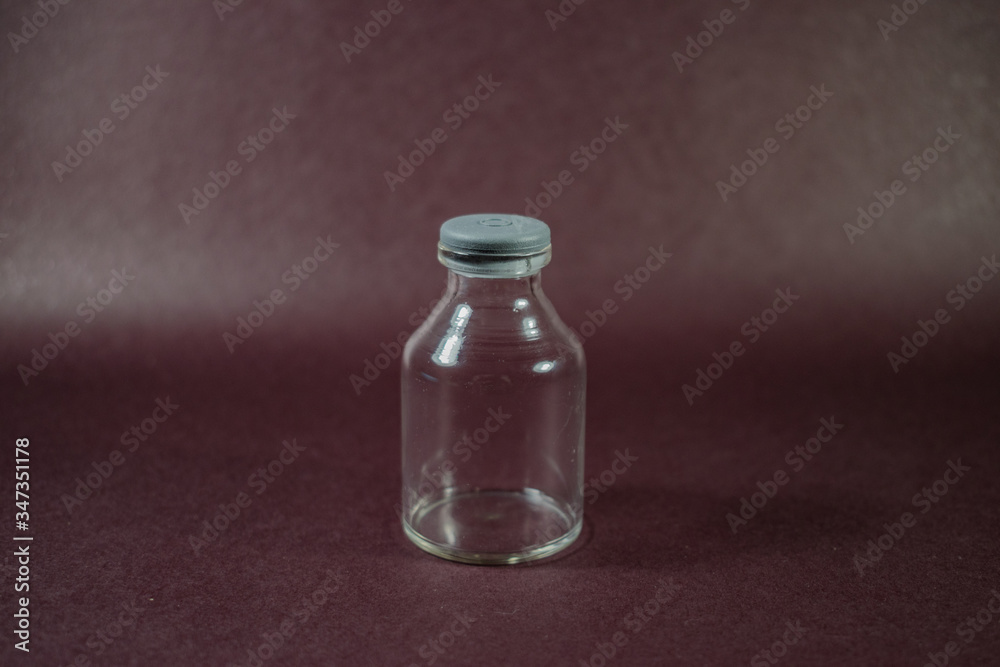 pequeña botella de vidrio transparente con tapón gris