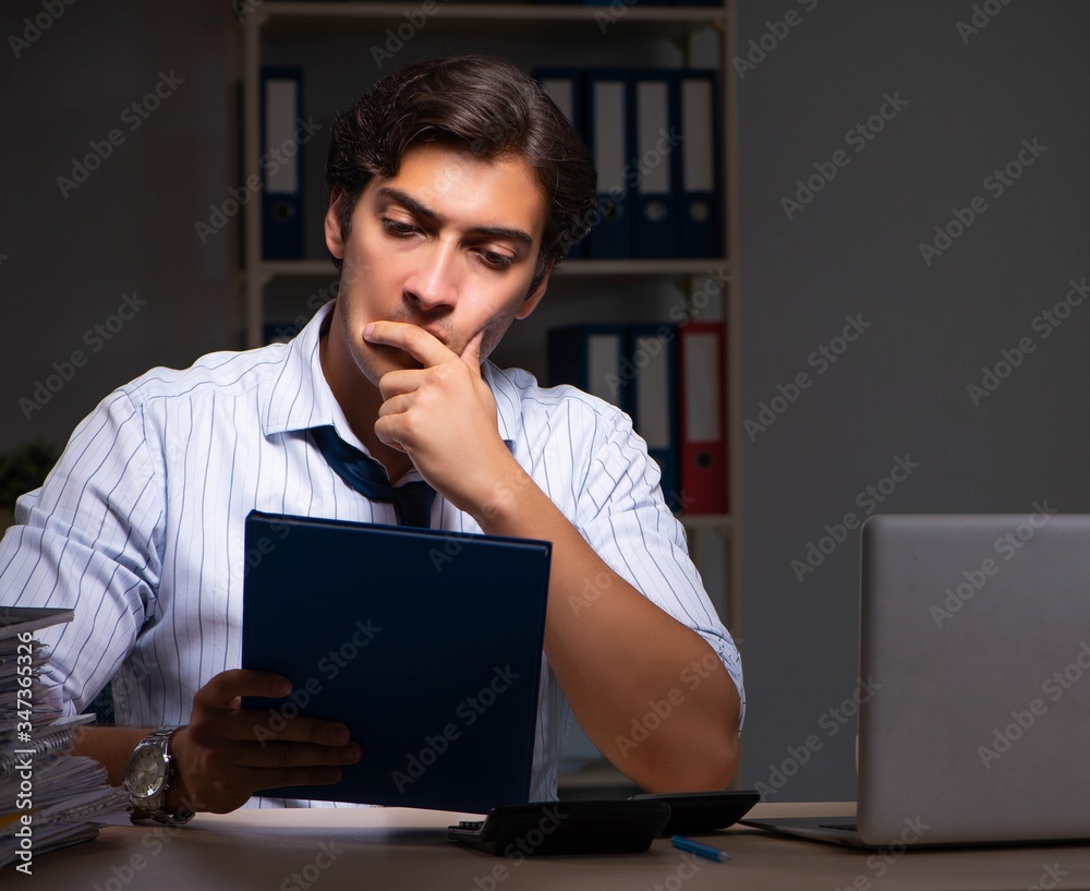 Young financial manager working late at night in office Young financial manager working late at night in office
