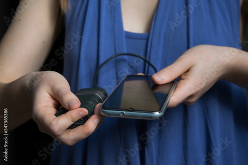 Woman holding mobile phone and a power block