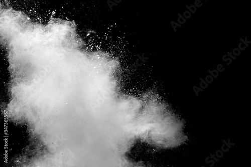 Freeze motion of white dust particles splash on black background.White powder explosion clouds.