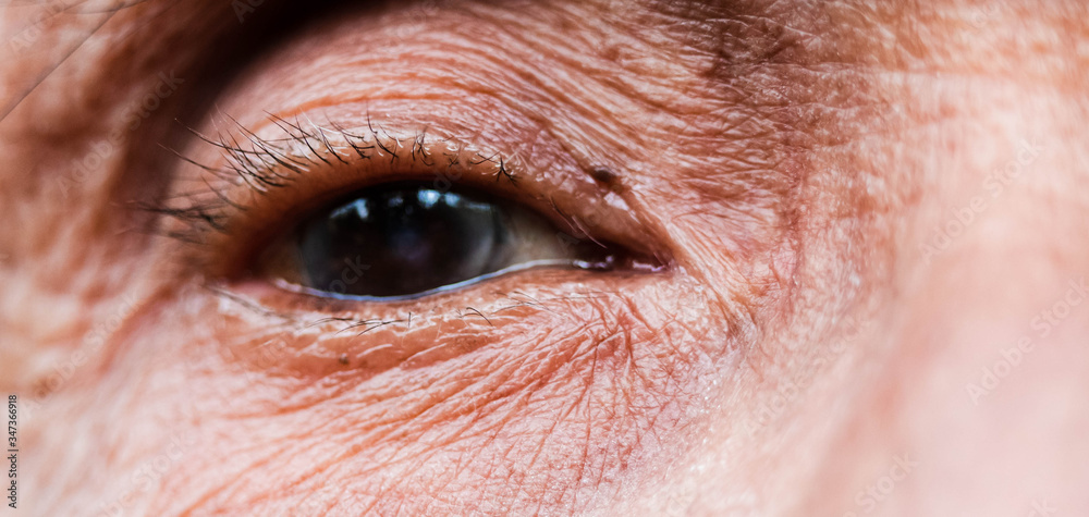 Fototapeta premium Close-up of one eye of an elderly Asian person with wrinkles around the eyes.