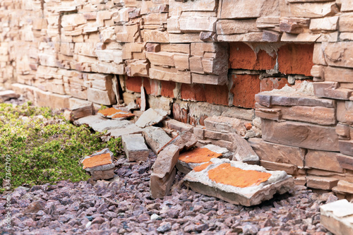 Fallen off decorative bricks from the wall.Сlose up.Soft focus.Сoncept of weather damage, improper installation of construction