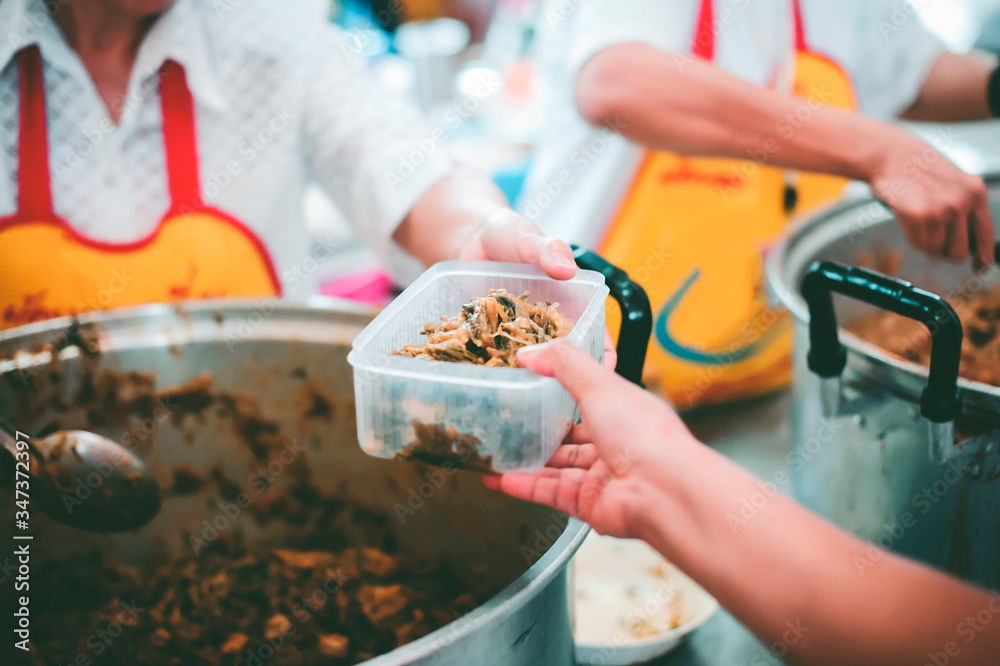 Obraz premium Volunteers serving food for poor people : concept of free food serving