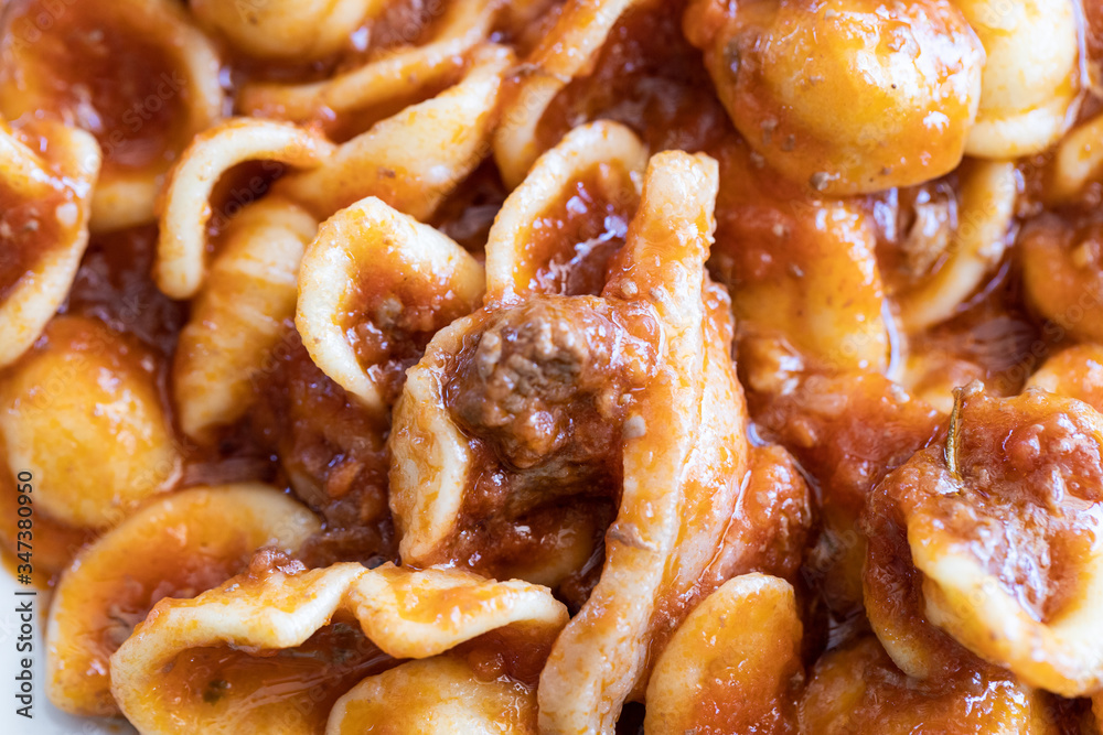 Lunch in a farmhouse in Puglia, in the south of Italy, during a hot summer day. A dish with homemade orecchiette and wild boar meat sauce. Lunch in a farmhouse in Puglia, in the south of Italy, during a hot summer day. A dish with homemade orecchiette and wild boar meat sauce.