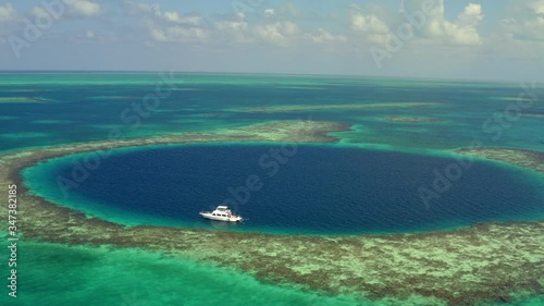 Aerial view of yacht in marine sinkhole against cloudy sky, scenic view of seascape - Great Blue Hole, Belize photo