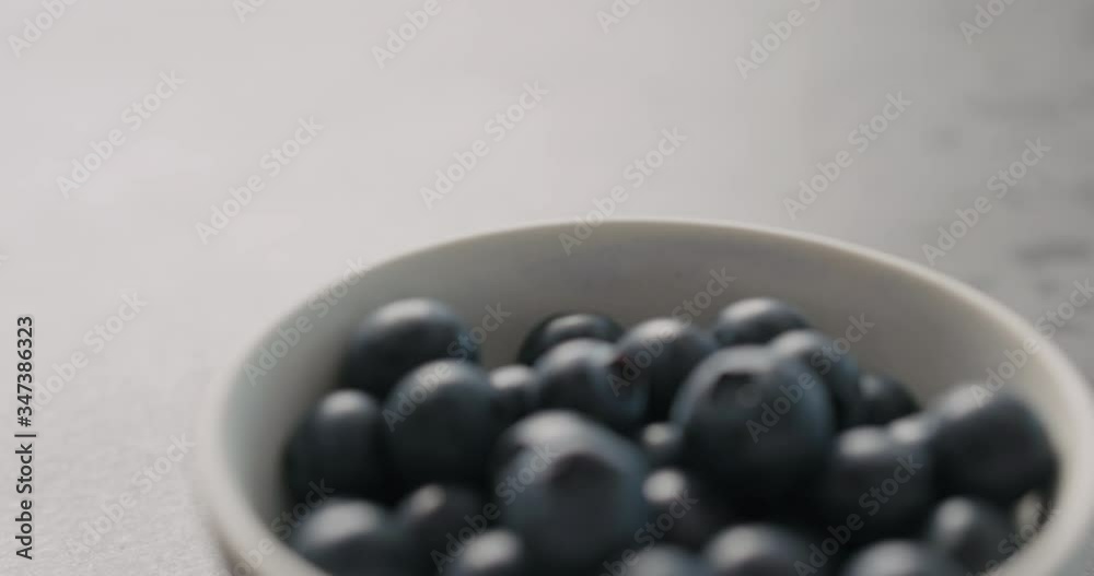 Slow motion handheld shot of ripe blueberries in white bowl closeup Slow motion handheld shot of ripe blueberries in white bowl closeup