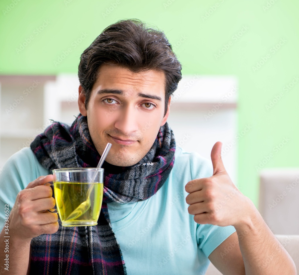 Young handsome man suffering from illness at home Young handsome man suffering from illness at home