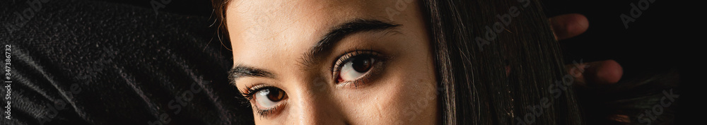 Obraz premium Low key close up of young woman with brown eyes.