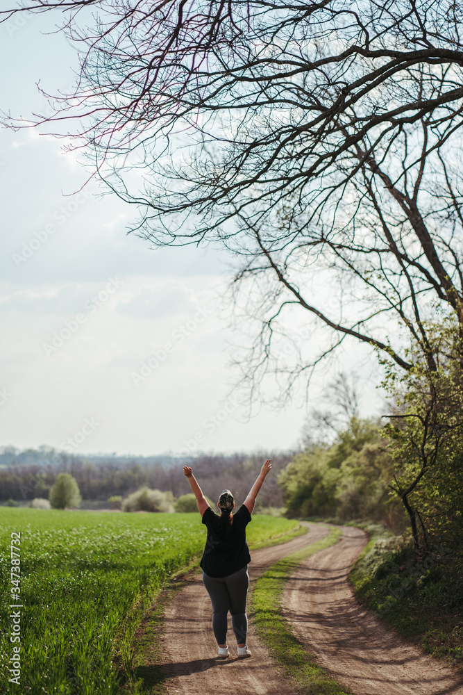 Happy woman standing in nature with open hands. Self esteem, body positive, life goals concept