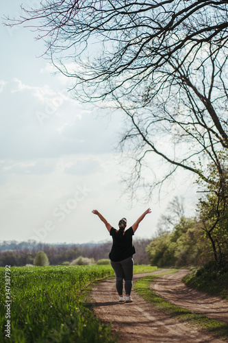 Body positive  success  freedom  happiness  confidence  self esteem. Overweight woman rising hands to the sky. Obesity and outdoor activity