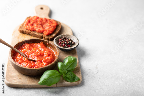 Balkan traditional dish ajvar on a wooden cutting board, place for text photo
