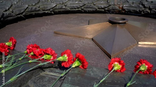 Quenchless Flame, red carnations and a bronze five-pointed star. War memorial to soldiers and heroes who fought for their homeland and died in World War II