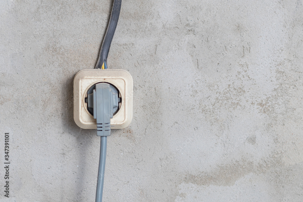 Electric sockets light works mounting and installation on plaster wall background. Professional installation of electrical outlets, wires and switches. Close up side view.