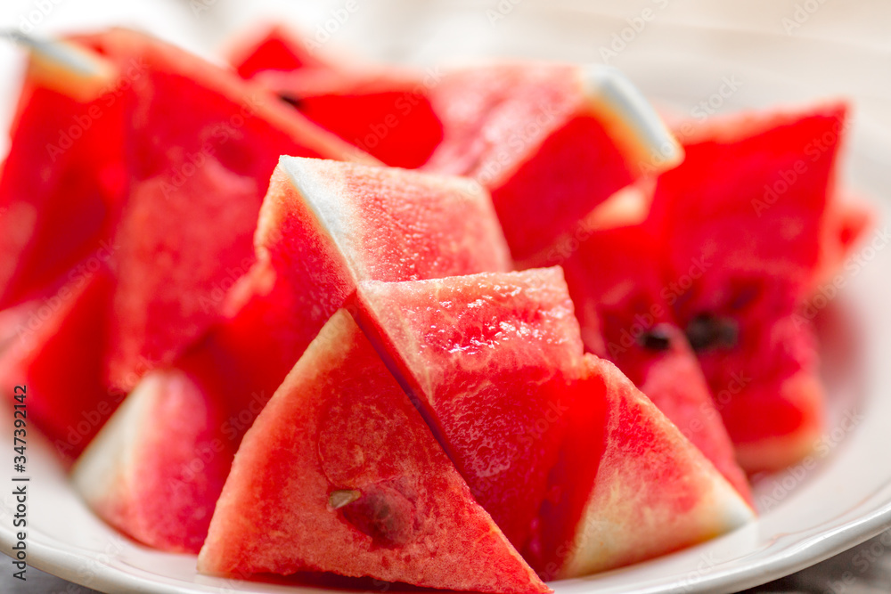 The background of the red flesh watermelon, placed in a ready-to-eat white plate, is a fruit that has a sweet taste and is an alternative health menu.