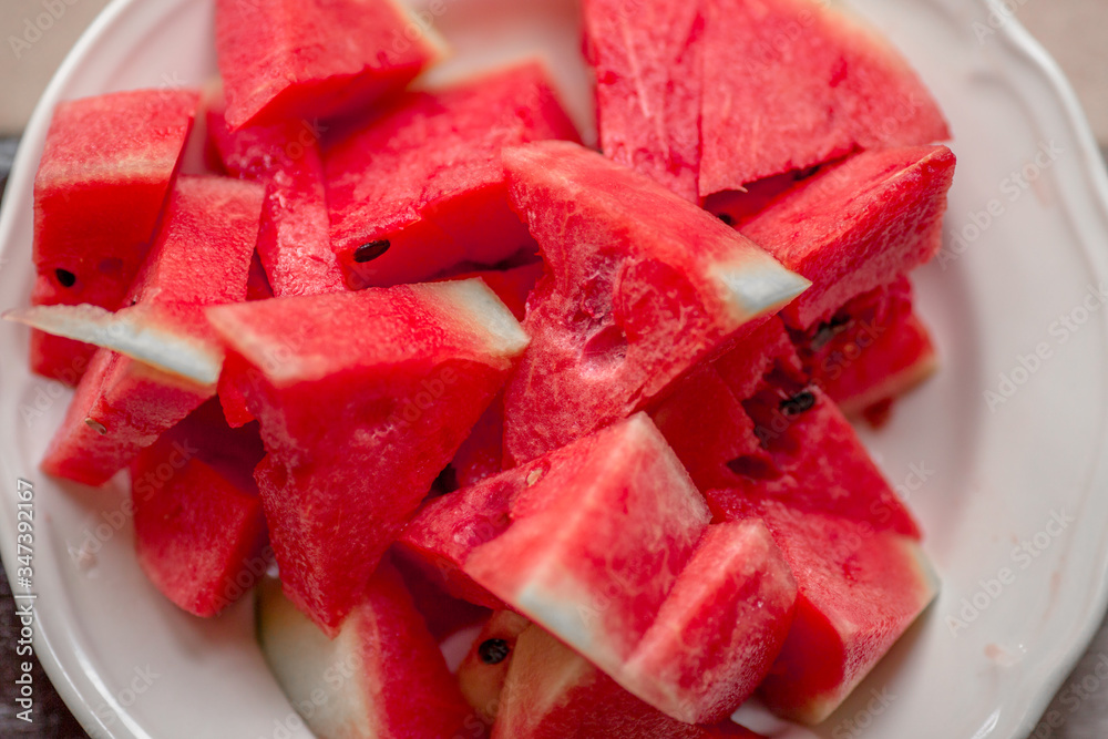 The background of the red flesh watermelon, placed in a ready-to-eat white plate, is a fruit that has a sweet taste and is an alternative health menu. The background of the red flesh watermelon, placed in a ready-to-eat white plate, is a fruit that has a sweet taste and is an alternative health menu.