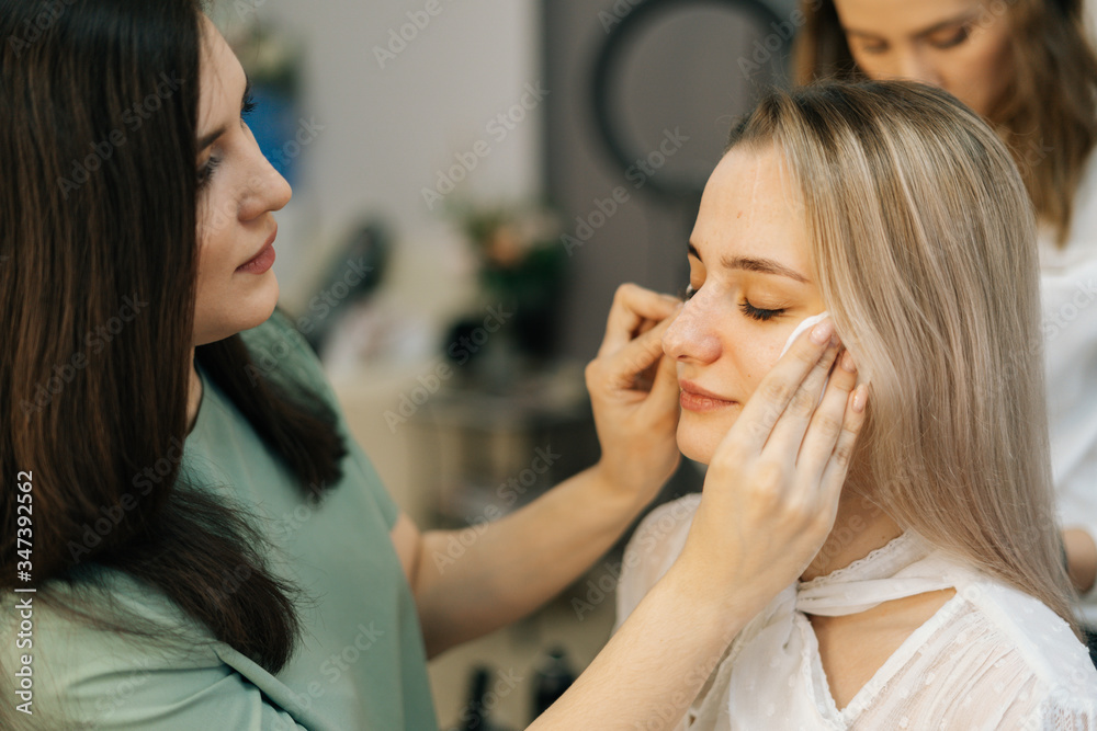 Close-up of beautiful woman model preparing for filming in lighting dressing room. Concept of backstage work. Close-up of beautiful woman model preparing for filming in lighting dressing room. Concept of backstage work.