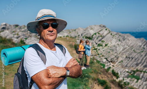 Senior man who practices trekking looking at camera