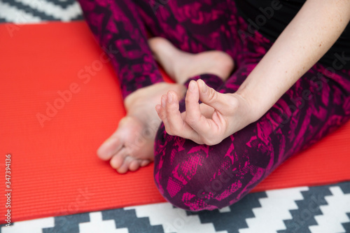 Beautiful young woman practicing yoga at home