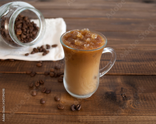 on a wooden table a glass of iced coffee