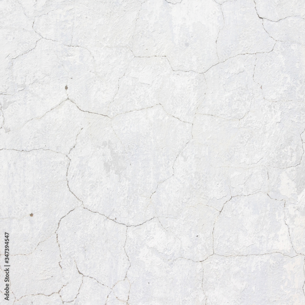 the white wall of an old house with beautiful cracks from time. white paint and whitewash on the wall. the background is white with soft blue and yellow. white old wall background the white wall of an old house with beautiful cracks from time. white paint and whitewash on the wall. the background is white with soft blue and yellow. white old wall background