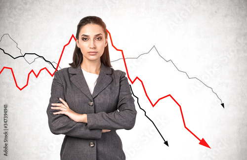 Serious young businesswoman, falling graphs