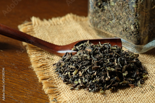 紅茶の茶葉とガラス瓶。tea leaves with a glass jar on a old wooden table