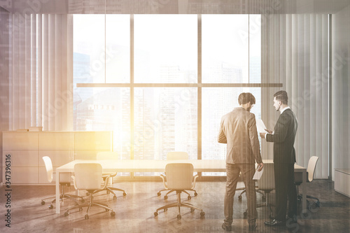 Businessmen in panoramic white meeting room