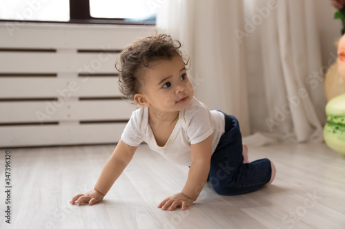 Fotografie Cute little african American toddler infant go on hands and knees learn to walk